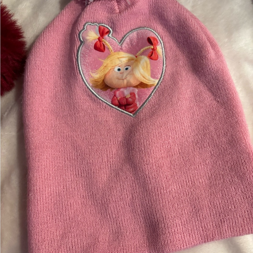 A pink knitted beanie featuring Cindy Lou Who from Dr. Seuss.